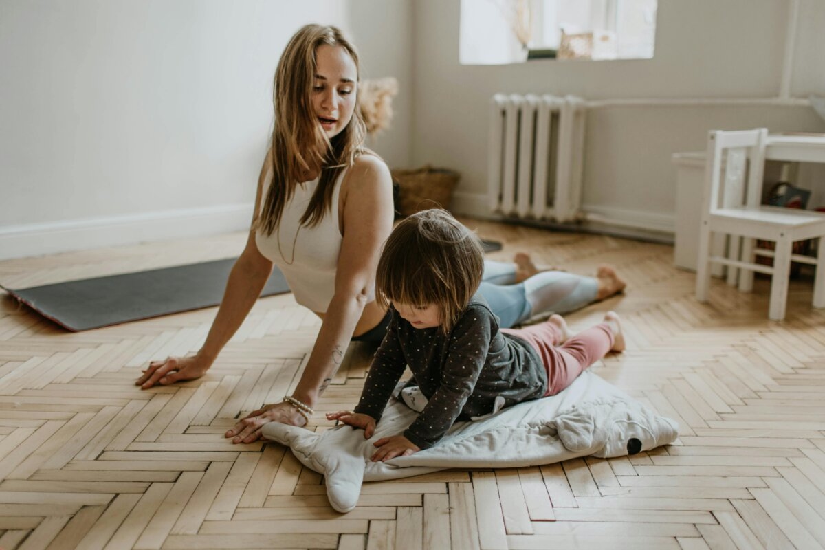 A mother and child practicing yoga together at home on a sunny day, fostering wellness and connection.