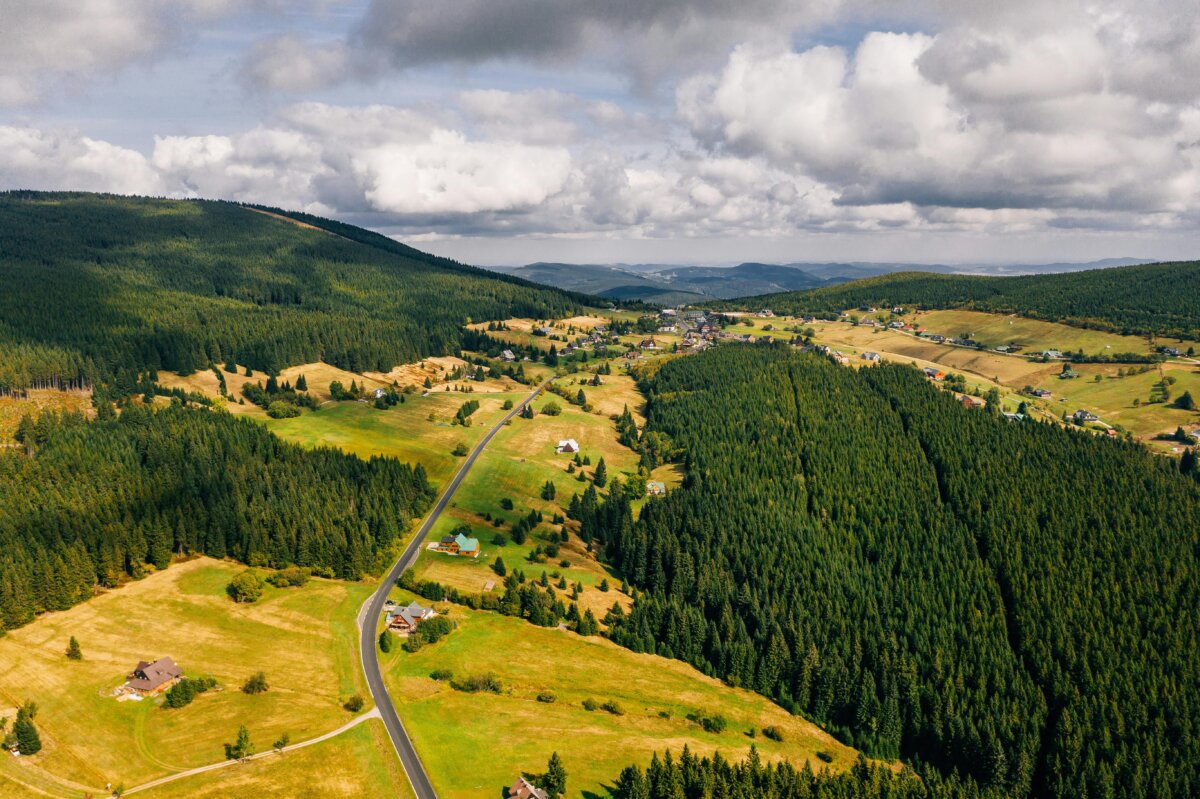 A stunning aerial view captures the lush forests and rolling hills of Malá Úpa, Czechia.
