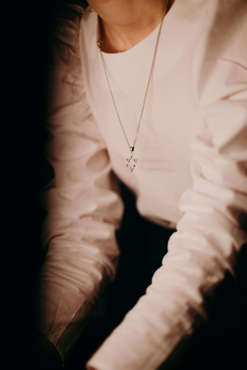 Close-up of a woman wearing a Star of David necklace, highlighting Jewish tradition and elegance.